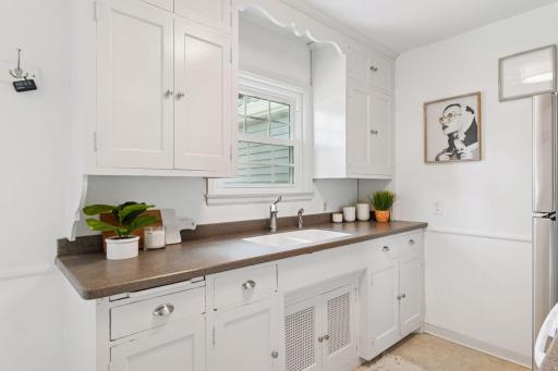 Solid surface countertops, deep sink, and views of the fully fenced private backyard.