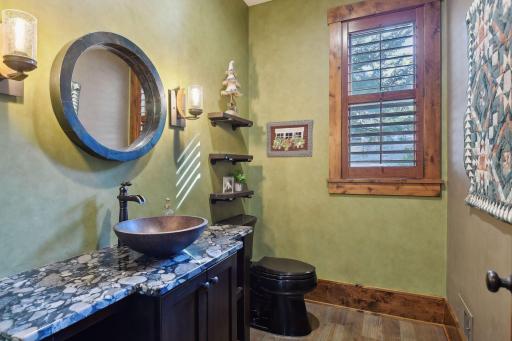 The powder room offers a furniture style vanity with granite counter