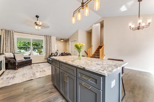 The kitchen island provides extra prep space, storage, and casual seating, while the informal dining area comfortably hosts larger gatherings.