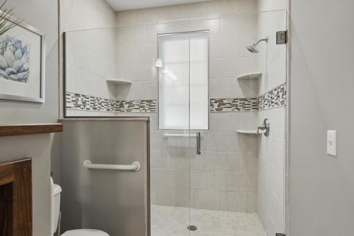 Newer spacious shower with a wall of glass