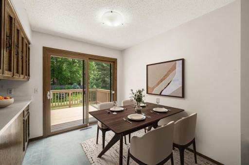 Informal dining area right off kitchen with sliding patio door to two-tiered deck. (virtually staged)