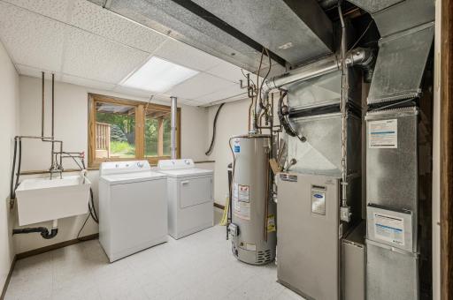 Laundry in basement with utility sink and newer mechanicals.