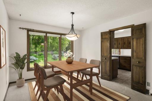 Formal dining room with French doors leading to kitchen. (virtually staged)