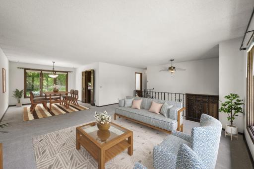 Bright living room with large picture windows and formal dining area. (virtually staged)