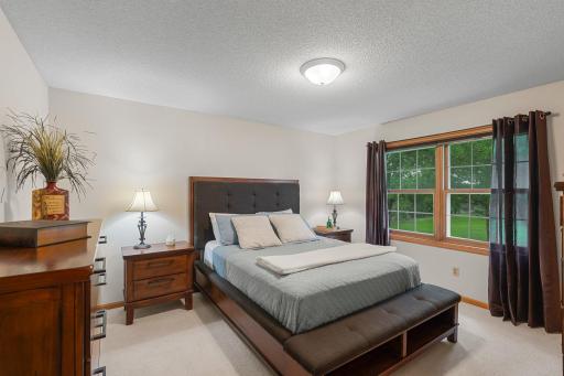 The primary bedroom, located on the upper level, features cozy carpeting, a large rear-facing window that fills the room with natural light, and a spacious 8x6 walk-in closet.