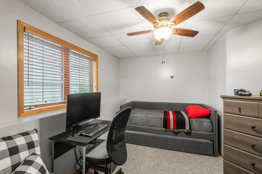 Located on the lower level, Bedroom 3 is carpeted, includes a ceiling fan, and features a built-in wardrobe for convenient storage.