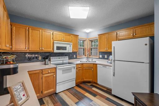 Ample oak cabinetry offers generous storage, and the kitchen features a reverse osmosis drinking water system, along with a brand-new refrigerator and dishwasher.