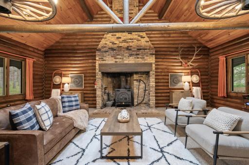 The living room is centered around a striking floor-to-ceiling brick fireplace, bringing both warmth and character to the space.
