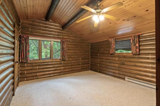 The primary bedroom is spacious with dual windows, vaulted ceilings, and a fan for added comfort.