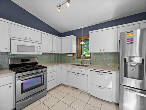 The kitchen features hard surface countertops and a stylish backsplash.