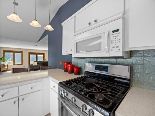 The kitchen features hard surface countertops and a stylish backsplash.