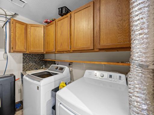 The utility room features extra cabinet space above the washer and dryer.