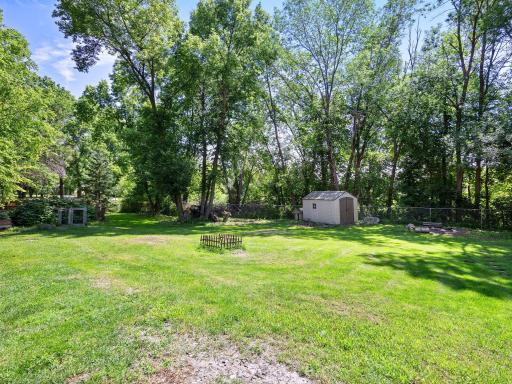 The expansive backyard is fenced in and lined with trees for additional privacy.