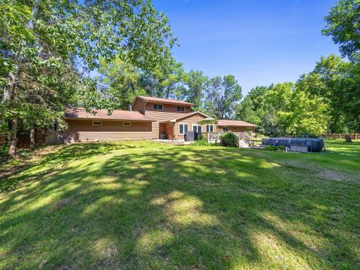 The expansive backyard is fenced in and lined with trees for additional privacy.