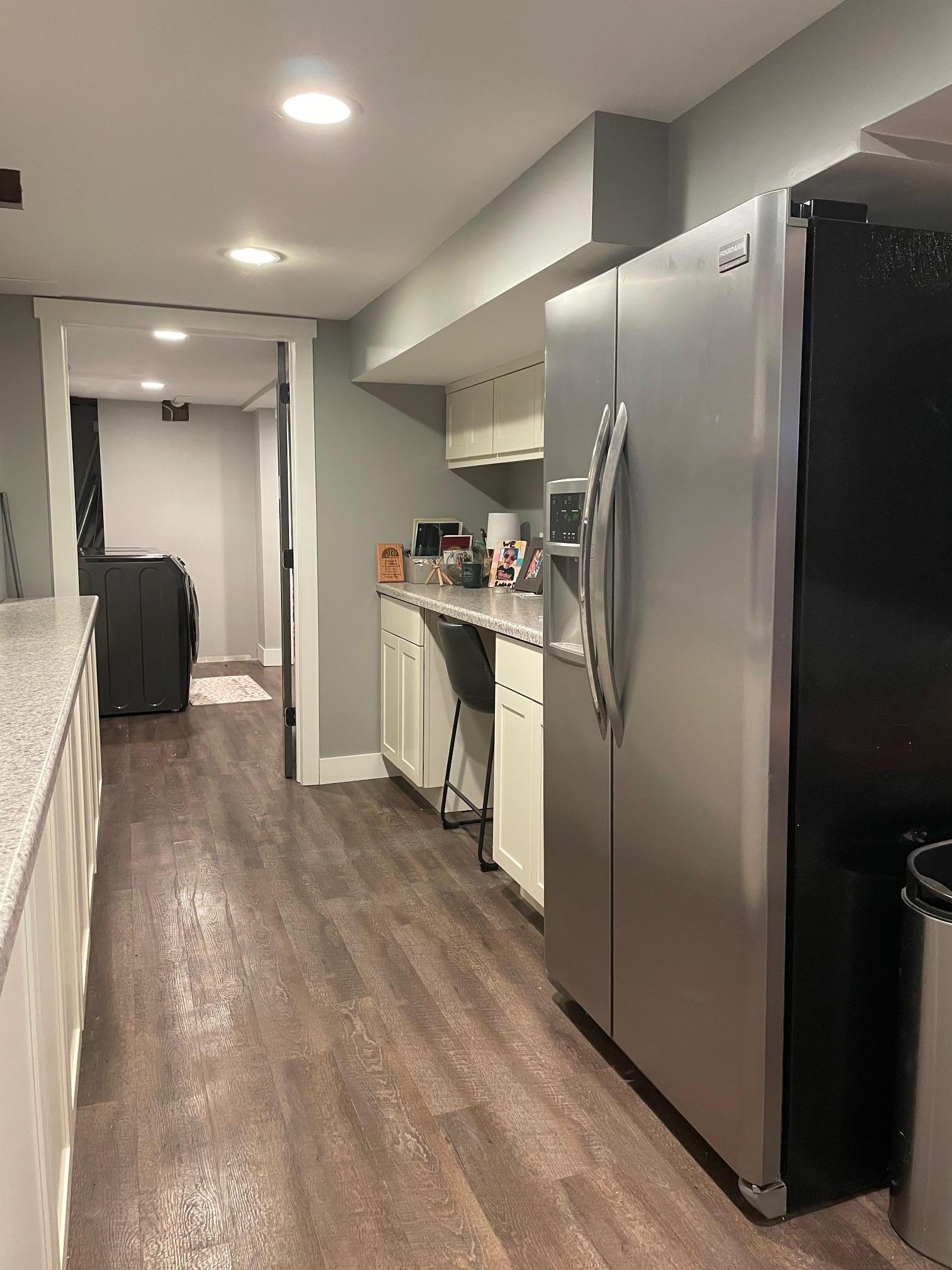 Wet bar in basement features a built-in desk.