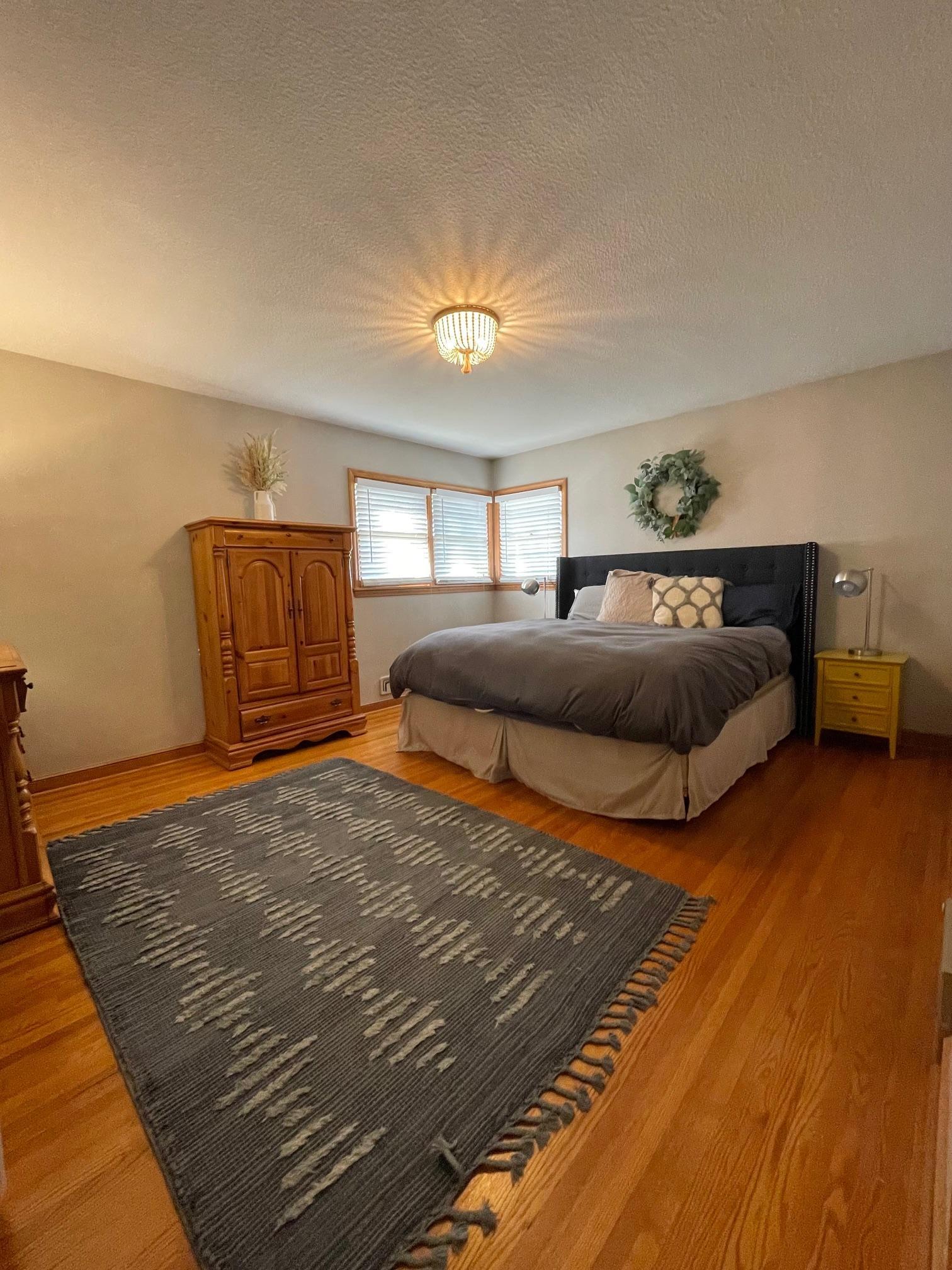Bedroom 1 features corner windows and hardwood flooring.