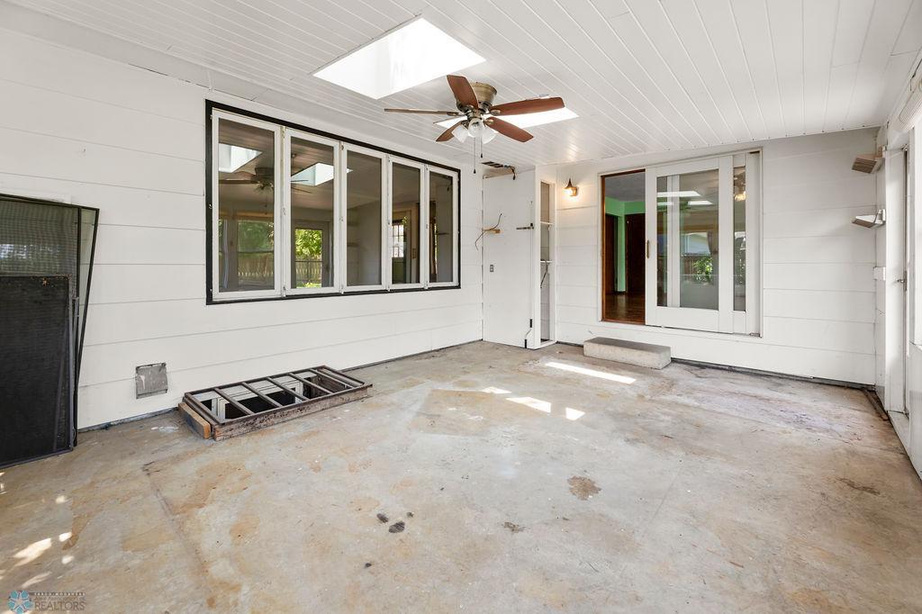 3-season Porch has concrete floors, ceiling fan, view to living & dining rooms.