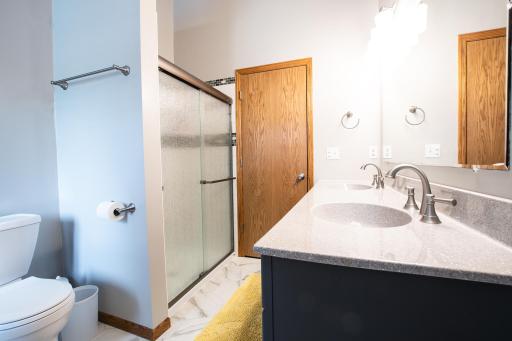 Newly remodeled upper full bath has tiled shower, tub and double vanity