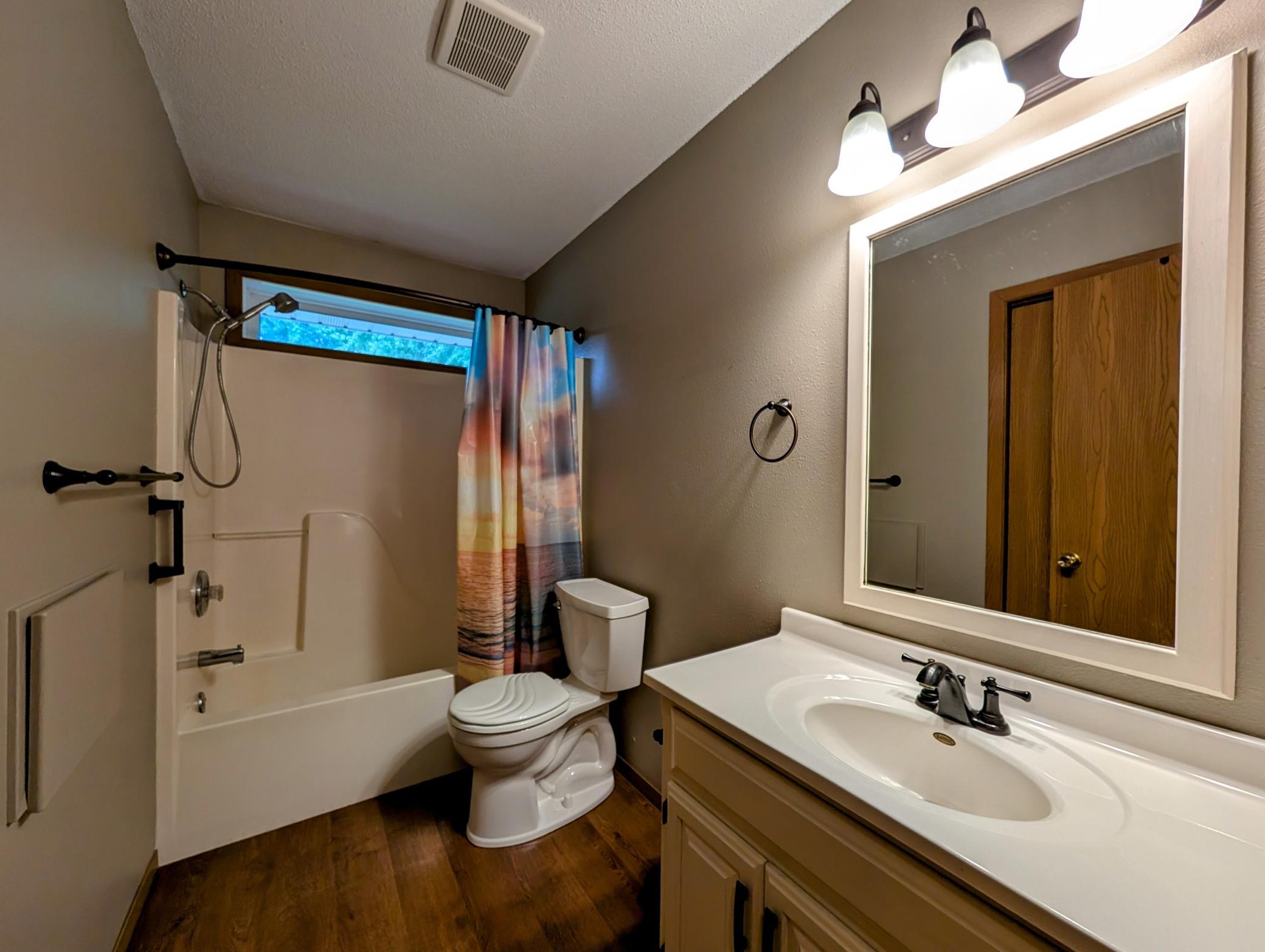 Full main floor bath features seamless tub/shower & clothes shoot to LL laundry area.