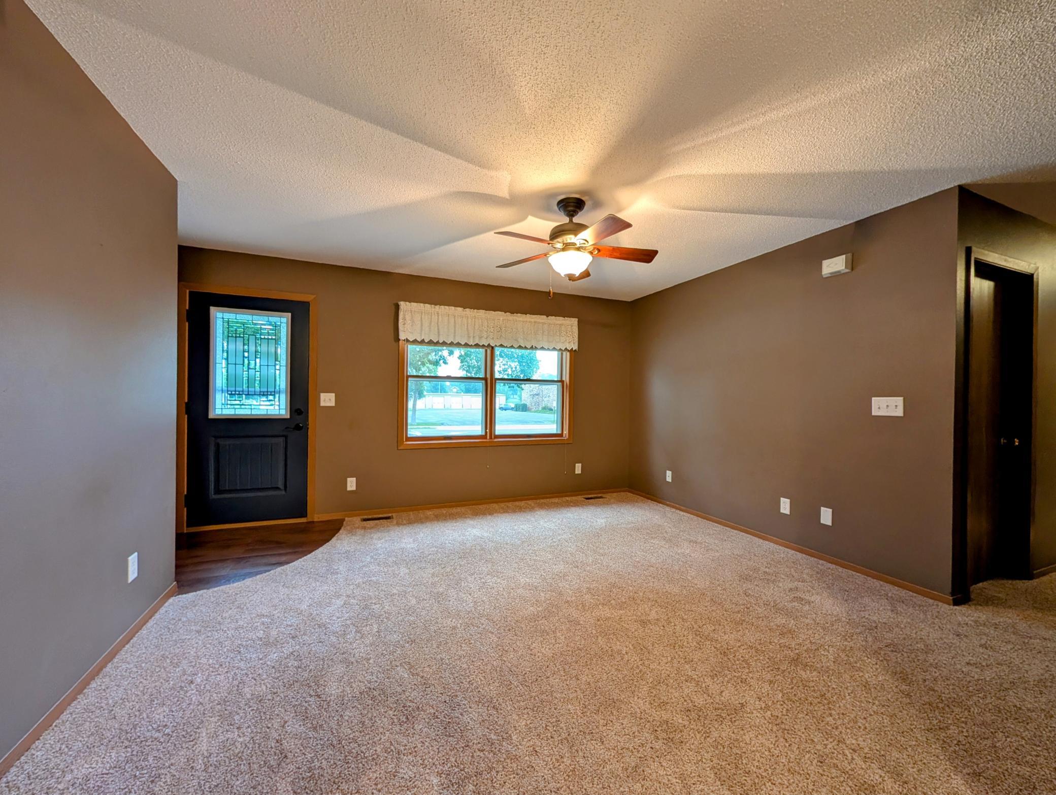 Custom blinds and ceiling fan plus guest closet enhance main floor living room.