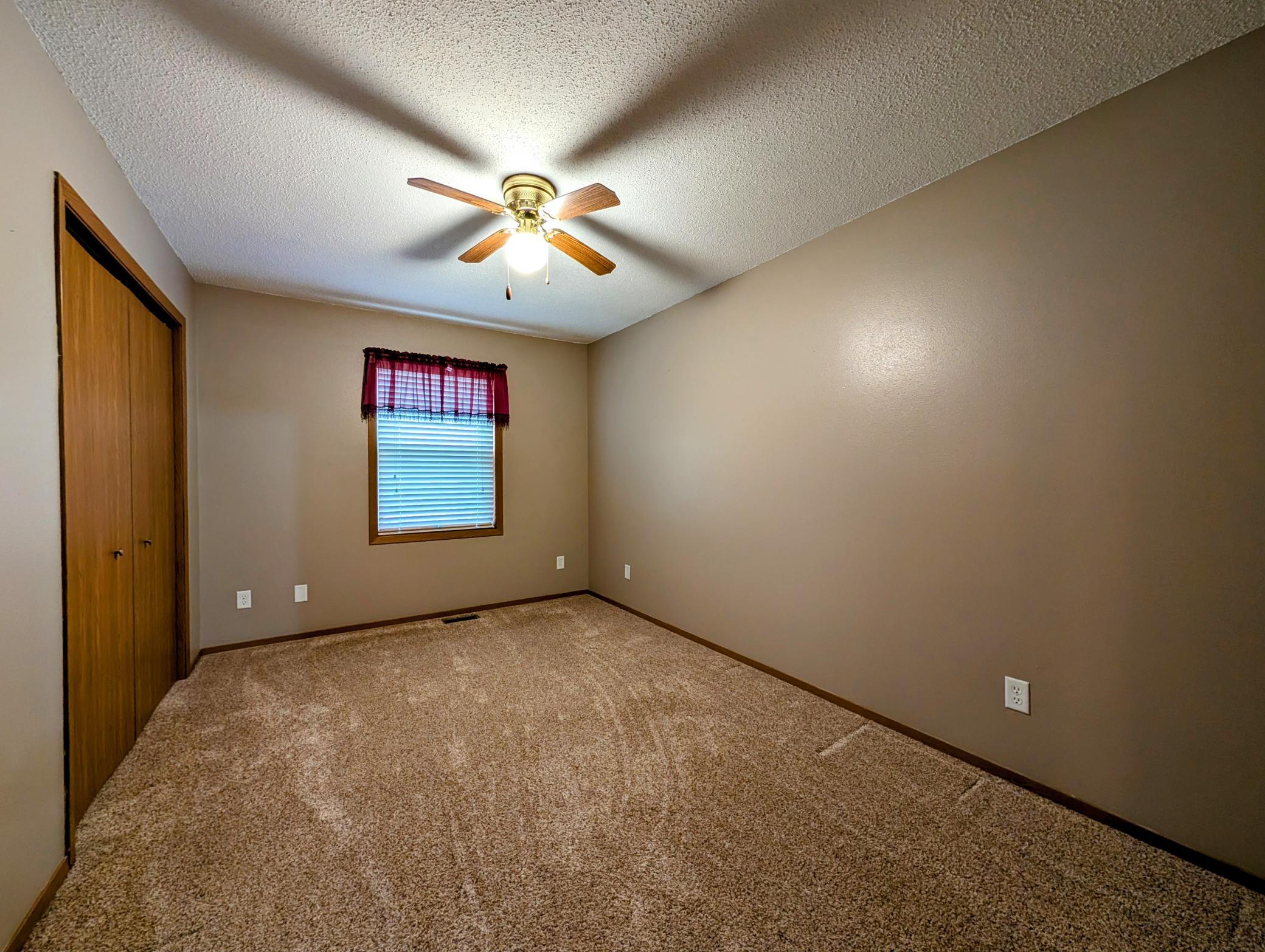 BR #1 features plush new carpet, neutral paint & ceiling fan.