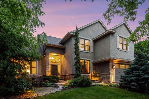 Welcome to 7216 Gunflint Trail - The home is surrounded by professional landscaping with a custom flagstone paver walkway and patio, landscape lighting and lush evergreens.
