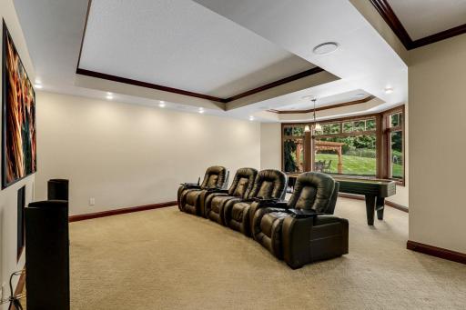The theater features a large screen, built in speakers and motorized blackout shades.