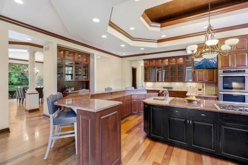 The chef’s kitchen features large windows, a double wall oven, 5-burner gas cooktop, built in microwave, generously sized refrigerator, abundant cabinet storage, 2 center islands and granite countertops.