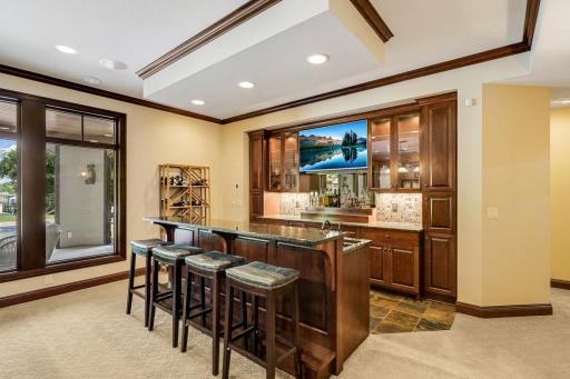 The entertaining common space includes a billiard room with a full bar which boasts a sink, beverage fridge, ice maker and a built-in microwave.