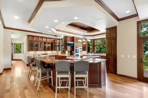 The chef’s kitchen features large windows, a double wall oven, 5-burner gas cooktop, built in microwave, generously sized refrigerator, abundant cabinet storage, 2 center islands and granite countertops.