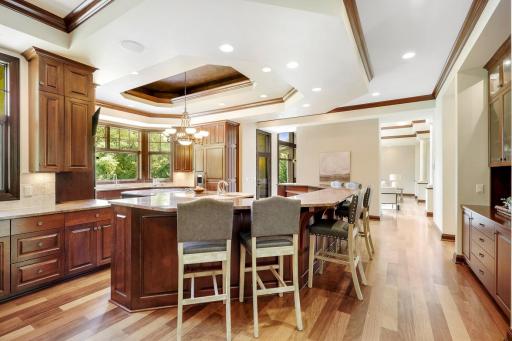 The chef’s kitchen features large windows, a double wall oven, 5-burner gas cooktop, built in microwave, generously sized refrigerator, abundant cabinet storage, 2 center islands and granite countertops.