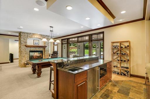 The entertaining common space includes a billiard room with a full bar which boasts a sink, beverage fridge, ice maker and a built-in microwave.