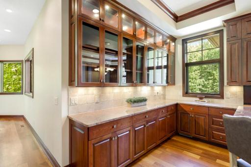 The chef’s kitchen features large windows, a double wall oven, 5-burner gas cooktop, built in microwave, generously sized refrigerator, abundant cabinet storage, 2 center islands and granite countertops.