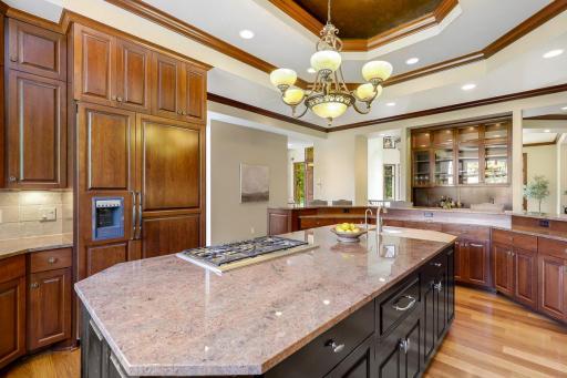 The chef’s kitchen features large windows, a double wall oven, 5-burner gas cooktop, built in microwave, generously sized refrigerator, abundant cabinet storage, 2 center islands and granite countertops.