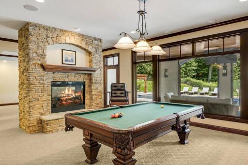 A cozy, double-sided fireplace separates the billiard room from the theater room.