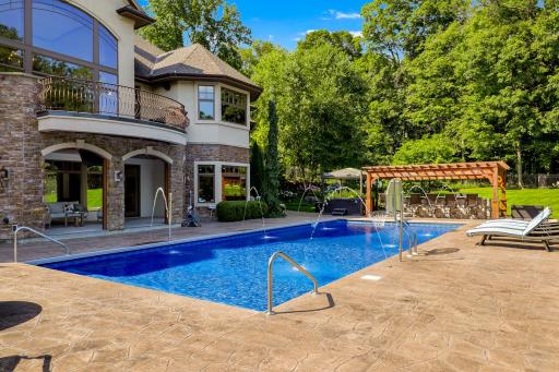 Stamped concrete encircles the pool area, and the private, mostly flat and fully fenced back yard provides ample space for yard games and outdoor relaxation.