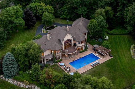A true resort awaits. A unique blend of classic architecture with modern design, this stately home was strategically positioned on the spacious acreage lot to maximize privacy, flat, usable yard space, natural daylight and sunrises over the lake.