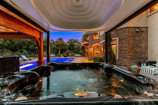 The hot tub features a motorized cover.