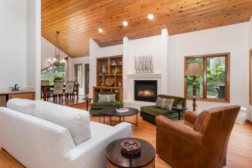 Soaring vaulted ceilings, skylights, and a gas brick fireplace make this living room a showstopper. Hardwood floors, built-in shelving, and warm lighting add the perfect finishing touches.