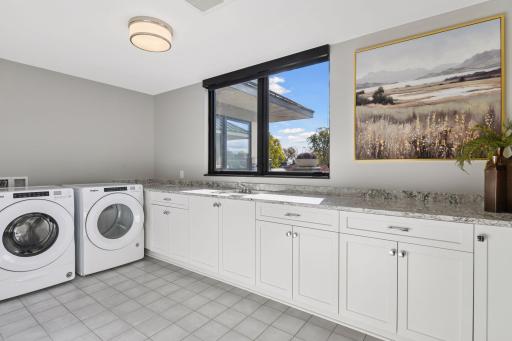 Large laundry room with cabinet space for storage, Cambria countertops, plus a long counter that is ideal for folding clothes