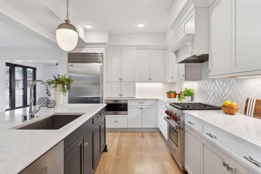 Kitchen space is thoughtfully appointed with high-end appliances, gas range, tiled backsplash, and plenty of cabinet space