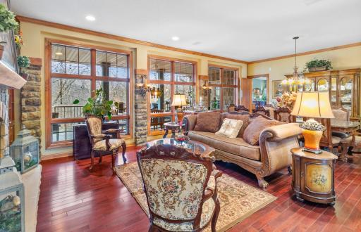 Living Room with mahogany hardwood flooring and floor-to-ceiling windows looking out to full length deck and back yard