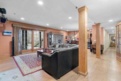 Lower-level recreation room. Walk-out slider to hot tub, rod iron fenced area and stairway to upper deck. View of wet bar and hallway to lower-level bedrooms.