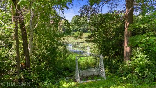 From yard toward pond at the height of summer. Relax on swing or launch your paddle boat or kayak.