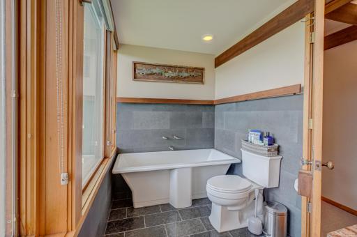 The luxurious Kohler soaking tub has faucets located on the slate-tiled wall so you can lie back and enjoy....