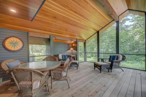 This screen porch designed by renowned architect Kelly Davis becomes the summer living and dining room. In 2017, Hagstrom Builder installed the Douglas fir ceiling.
