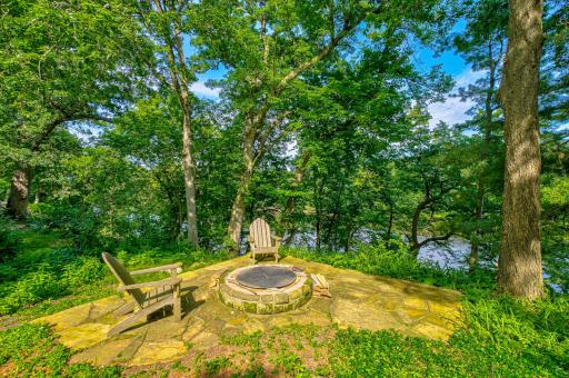 This north patio area off the screen porch deck has a built-in fire pit and a beautiful view of the river.