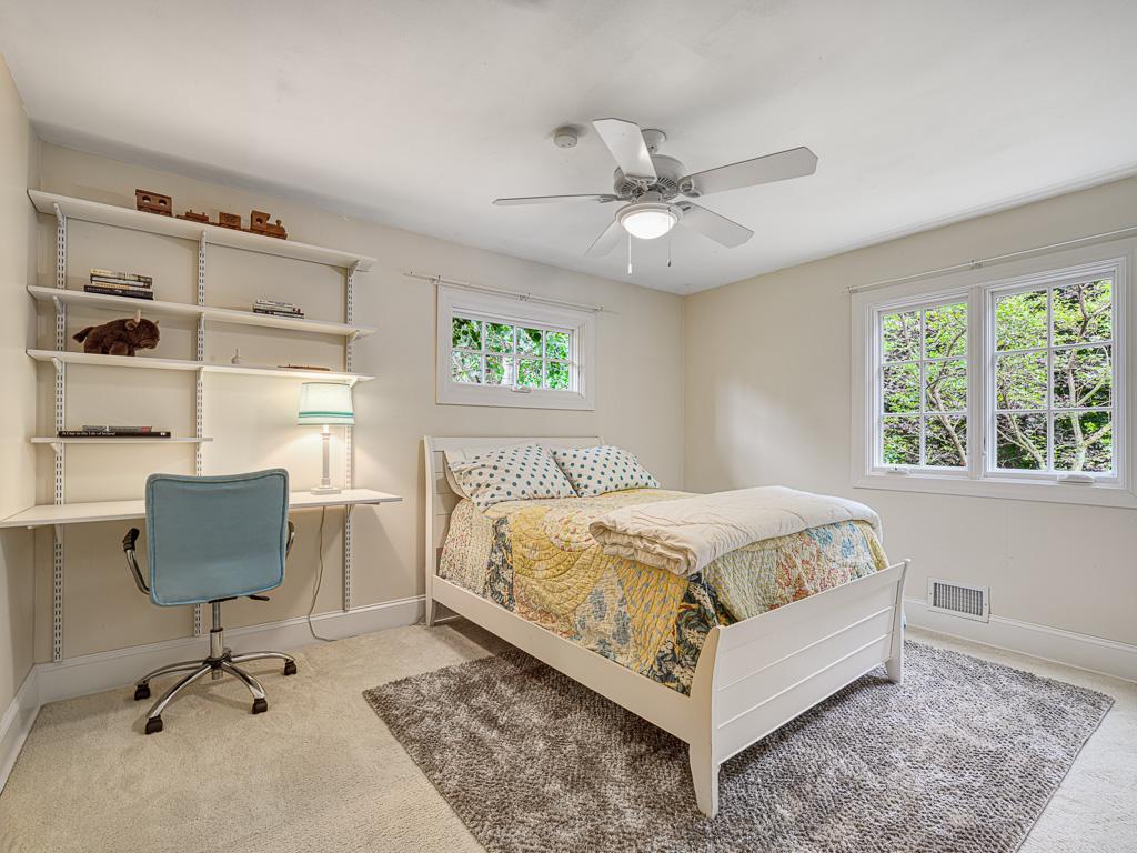 Another upstairs bedroom offers beautiful garden views, creating a peaceful retreat
