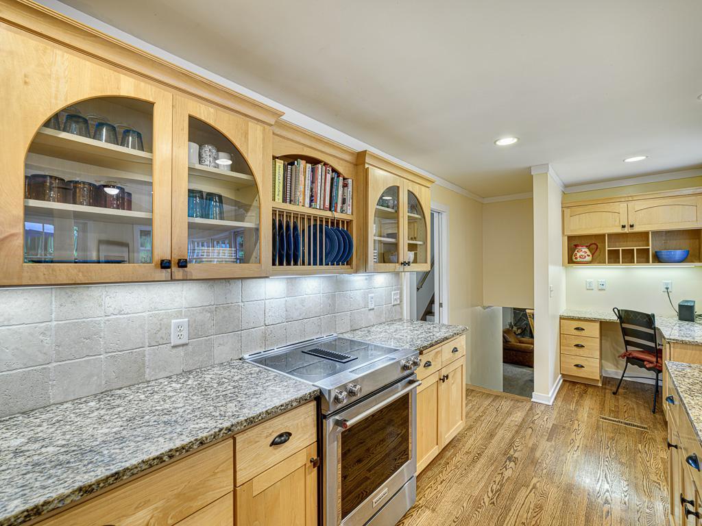 The kitchen showcases stunning custom cabinetry paired with a stylish tiled backsplash