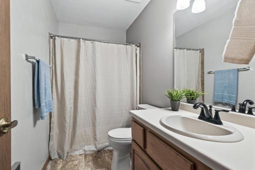 The main bathroom includes a convenient bathtub/shower combo, updated luxury vinyl tile flooring, and ample cabinet storage space in the vanity.
